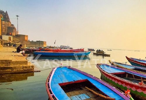 Blue boats on the Ganga at first light beside the ghat steps