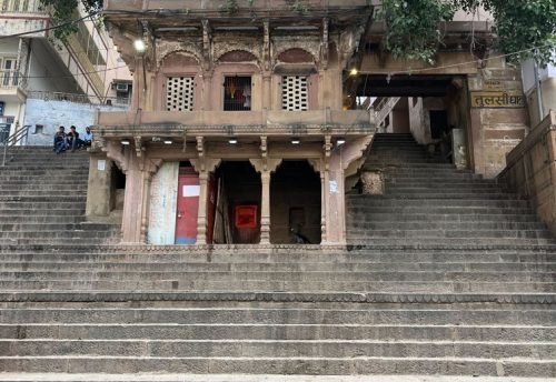 A temple building above the stone steps of Tulsi Ghat in Varanasi