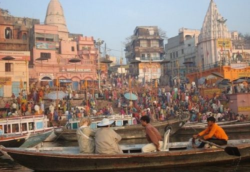 A rowing boat among the crowded ghats of Varanasi