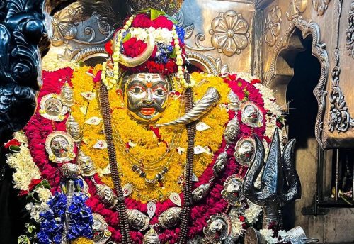 The complete Kal Bhairav shrine decorated with flowers and silver ornaments
