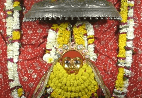 The face of Goddess Durga covered with yellow and red flowers