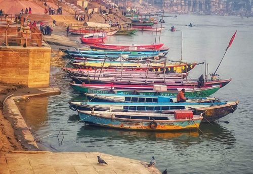Colourful boats moored along the steps at Assi Ghat