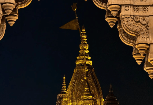 The golden Kashi Vishwanath Temple spire illuminated at night