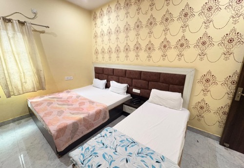 Triple Bed Room beds against the accent wall, Hotel Shivala Grand